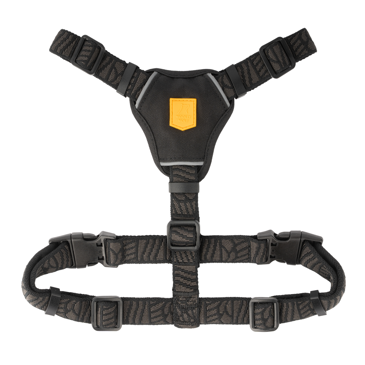 Black dog harness with a yellow logo patch and adjustable straps.